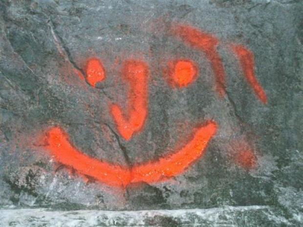 Grafitti av et smil på bergvegg. Foto.