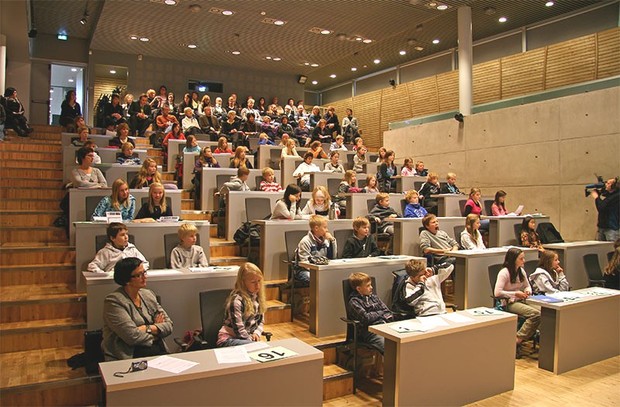 Barn og unge i forelesningssal. Foto.