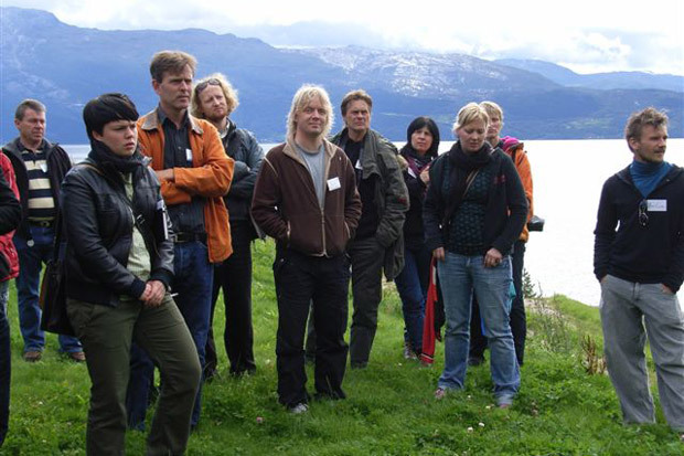 Personer. Fjord i bakgrunnen. Foto.