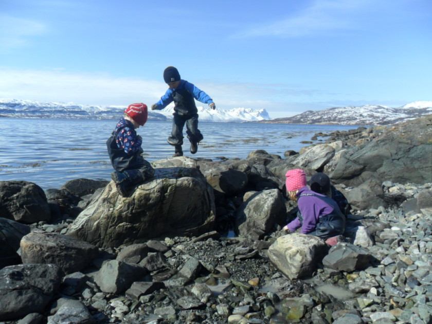 3 barn som leker i vannkanten. Foto.