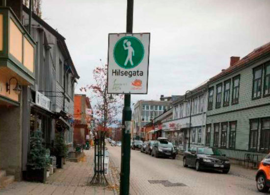 Gatemiljø i Levanger - skilt med mann som hilser. Foto.