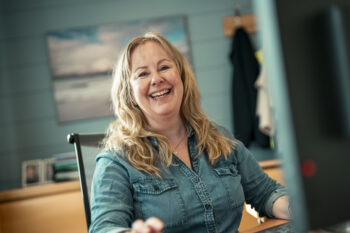 Smilende dame ved kontorpult